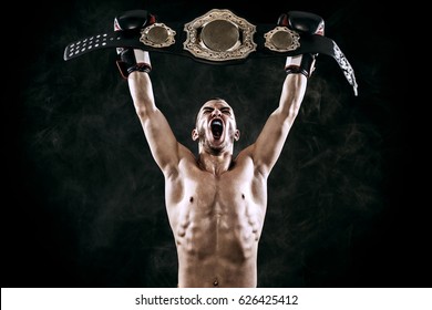 Boxer with Champion belt celebrating flawless victory isolated on black background with copy Space.. - Powered by Shutterstock