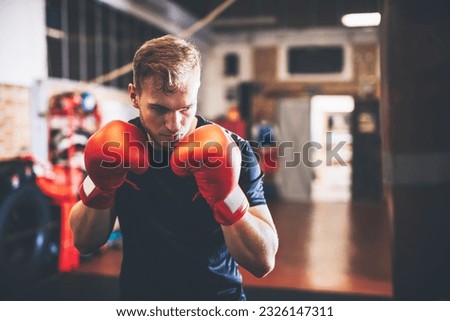 Boxer do boxing training with punchbag on a gym