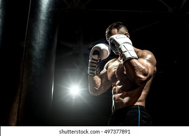 boxer in gym with boxing gloves, safeguard stand, black bacground, horizontal photo - Powered by Shutterstock