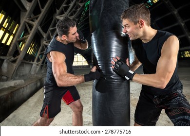 
Boxer Man During Boxing Hitting Heavy Bag At Training