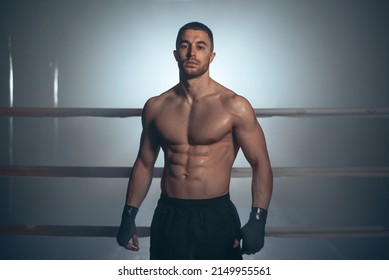 Boxer, man posing in bandage on boxing ring. Fitness and boxing concept. High quality photo