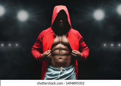 Boxer man workout in boxing ring. Black fighter in hoodie, stadium lights background - Powered by Shutterstock