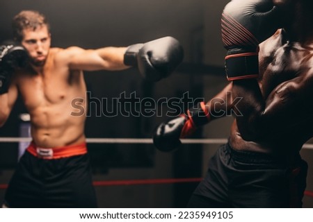 Boxer missing his opponent during a fight in a boxing ring. Two male boxers having a boxing match in a gym.