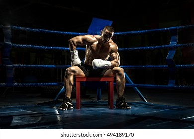 boxer on boxing ring, tired time-out,  black bacground, horizontal photo - Powered by Shutterstock