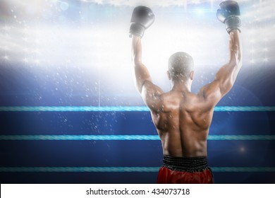 Boxer Posing After Victory Against Composite Image Of Boxing Ring