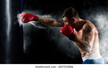 Boxer in red gloves at the moment of impact on punching bag. Sports banner. Horizontal copy space background