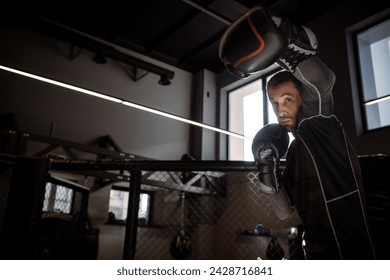 Boxer throwing powerful left hook during shadowboxing in gym
