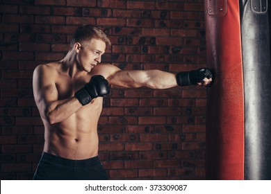 Boxer training on a punching bag in the gym. - Powered by Shutterstock