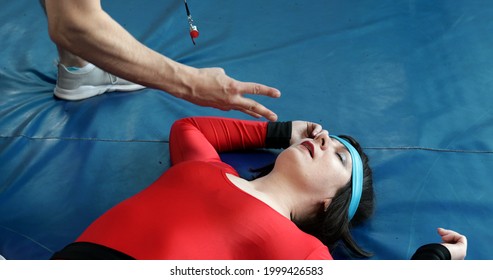 Boxer Woman Lies To Boxing Ring Floor After Knockout Punch. The Judge Counts With His Fingers.