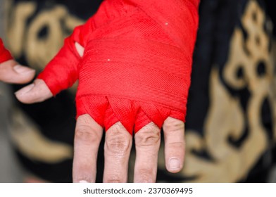 Boxer's hand wrapped in red bandage - Powered by Shutterstock