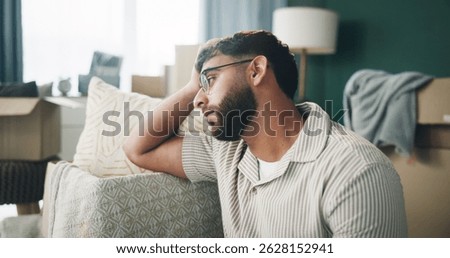 Boxes, depression and thinking with man on sofa in living room of home for mortgage failure or mistake. Grief, loss and sad with unhappy person in apartment for bankruptcy, debt or eviction crisis
