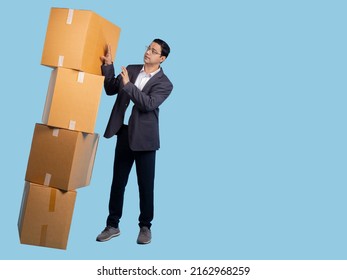 Boxes fall on man. Businessman catches cardboard boxes. Guy with boxes on turquoise. Business concept for selling goods service internet. Cardboard parcels are ready to be sent. Human business owner