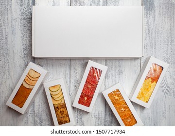 Boxes of fruit chips lie on a white wooden background