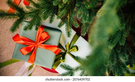 A Boxes With A Gift In Green Packaging Paper With Red And Green Ribbon Under The Christmas Tree. Surprise Gift For New Year. Gift Wrapping Service.