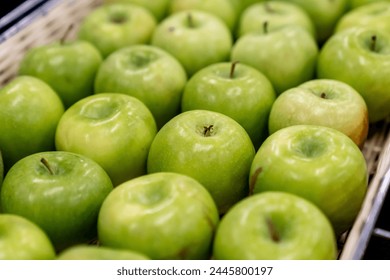Boxes of juicy group green apples in the supermarket. sold in market, supermarket. a pile of fresh green apples neatly arranged in a fruit shop, fruits background concept
					