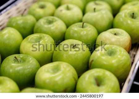 Boxes of juicy group green apples in the supermarket. sold in market, supermarket. a pile of fresh green apples neatly arranged in a fruit shop, fruits background concept
