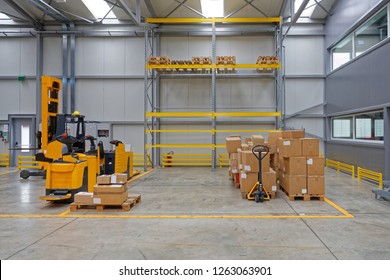 Boxes At Pallet Truck And Electric Forklifts In Distribution Warehouse