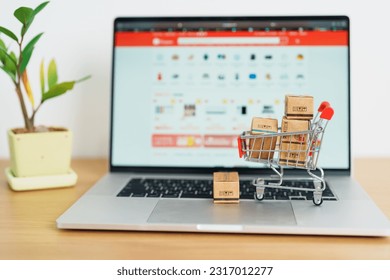 Boxes with shopping cart on a laptop computer. online shopping, Marketplace platform website, technology, ecommerce, shipping delivery, logistics and online payment concepts