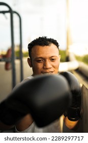 Boxing athlete model posing for the camera wearing black gloves