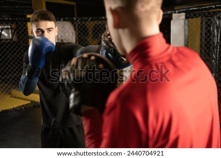 Boxing athlete punch to his opponent in sparring. Two male boxers fighting in a boxing ring. Copy space