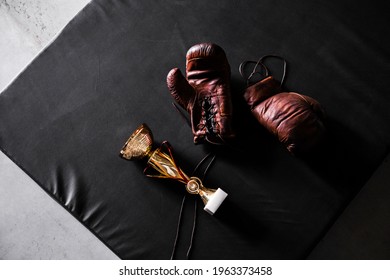 Boxing Gloves With A Cup On A Black Background Top View. Mockup