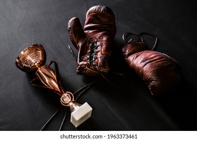 Boxing Gloves With A Cup On A Black Background Top View. Mockup