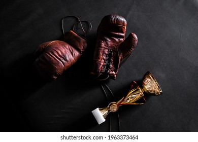 Boxing Gloves With A Cup On A Black Background Top View. Mockup