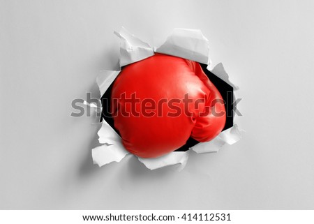 Boxing gloves knockout punch punching through torn paper hole ready for message on glove
