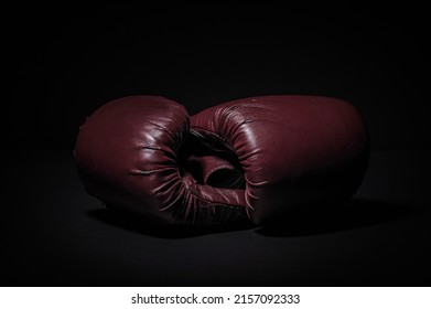 Boxing Gloves In A Low Light Room With Black Background