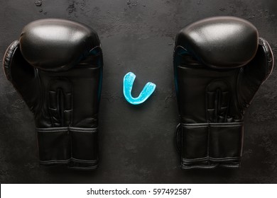 Boxing Gloves And A Mouth Guard On A Black Background