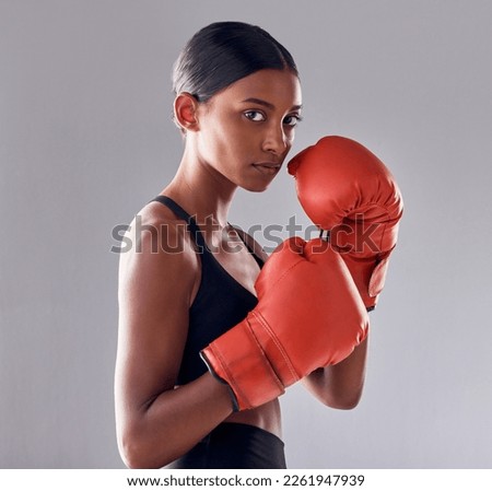 Boxing, gloves and portrait of woman in studio for sports exercise, strong muscle or mma training. Indian female boxer, workout and fist fight for impact, energy and warrior power in battle challenge