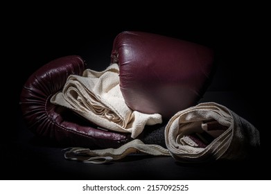 Boxing Gloves And Wraps In A Low Light Room With Black Background