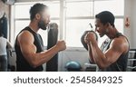 Boxing, man and personal trainer in gym with fist bump, motivation and training for sport and strength in wellness club. Coach, smile and sweating athlete and boxer with exercise for fight and match