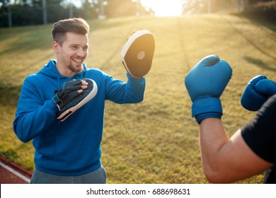 boxing outdoor workout with trainer; punching exercises with personal coach; - Powered by Shutterstock