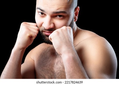 Boxing Stance. Close Up Portrait Of Strong Confident Shirtless Man With Beard Keeping Fists Against Black Background.