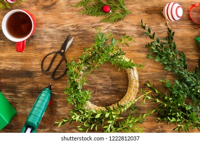 Boxwood Christmas Wreath. DIY Christmas Decoration Concept. Wooden Desk Top View.