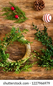 Boxwood Christmas Wreath. DIY Christmas Decoration Concept. Wooden Desk Top View.