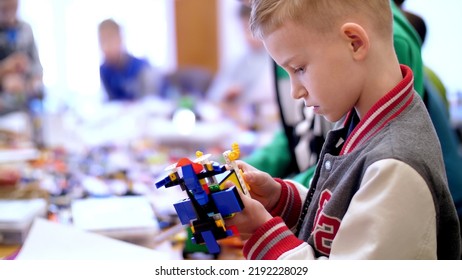 The Boy Of 10 Years, Plays In The Designer From Cubes, Plates, Circuits, Wires. A Small Inventor Creates Robots, Machines From Different Parts Of The Designer. High Quality Photo