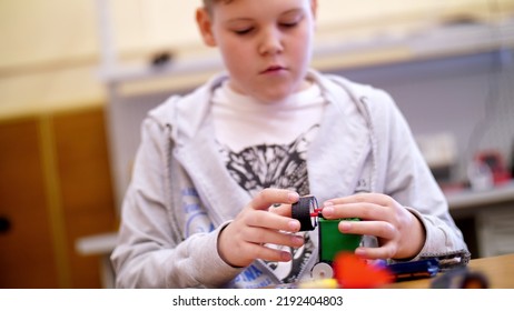 The Boy Of 11 Years, Plays In The Designer From Cubes, Plates, Circuits, Wires. A Small Inventor Creates Robots, Machines From Different Parts Of The Designer. High Quality Photo