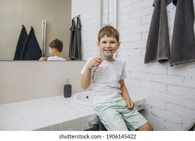 Boy 5-7 Years Old Brush His Teeth In The Bathroom. 