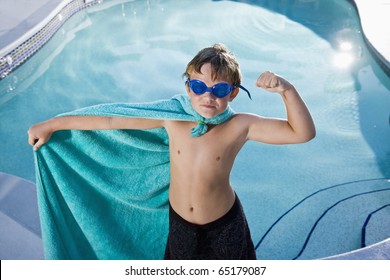 Boy, 9 years, playing by swimming pool in pretend superhero costume flexing muscles - Powered by Shutterstock