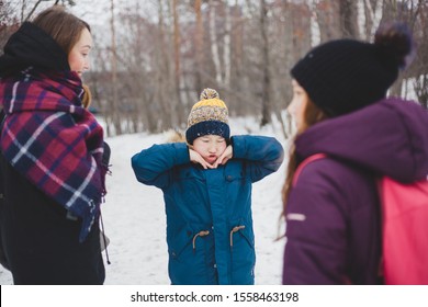 Boy antics on a walk with his family in a winter Park or forest