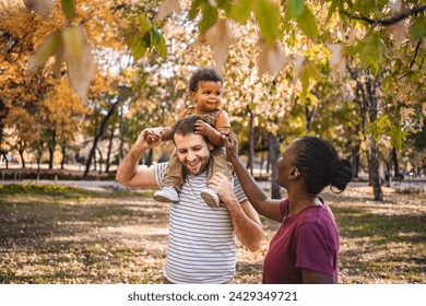 Boy in the arms of his parents in the park - Powered by Shutterstock