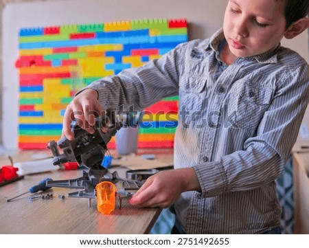 Boy Assembling Complex Mechanical Toy Robot with Wires and Screws on Desk, Child Engineering STEM Model Kit at Home