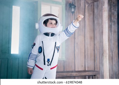 boy in astronaut costume flying on porch