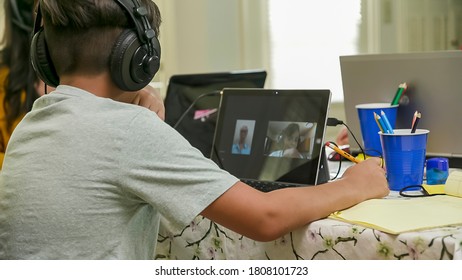 A boy attending school in a virtual classroom interacts with his teacher in the new normal due to school closures in response to the pandemic.