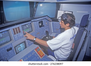 A Boy Attending Space Camp At The George C. Marshall Space Flight Center In Huntsville, Alabama, Sits In The Cockpit Of A Space Shuttle Flight Simulator