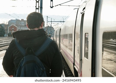 Boy with a backpack walking next to a train Valladolid Spain train stations northern Spain traveling by train  