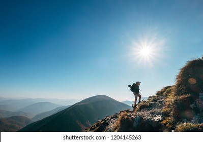 Boy backpacker traveler walk up on mountain top in contrast sun light - Shutterstock ID 1204145263