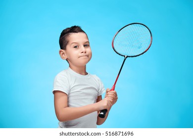 The boy with badminton rackets outdoors
